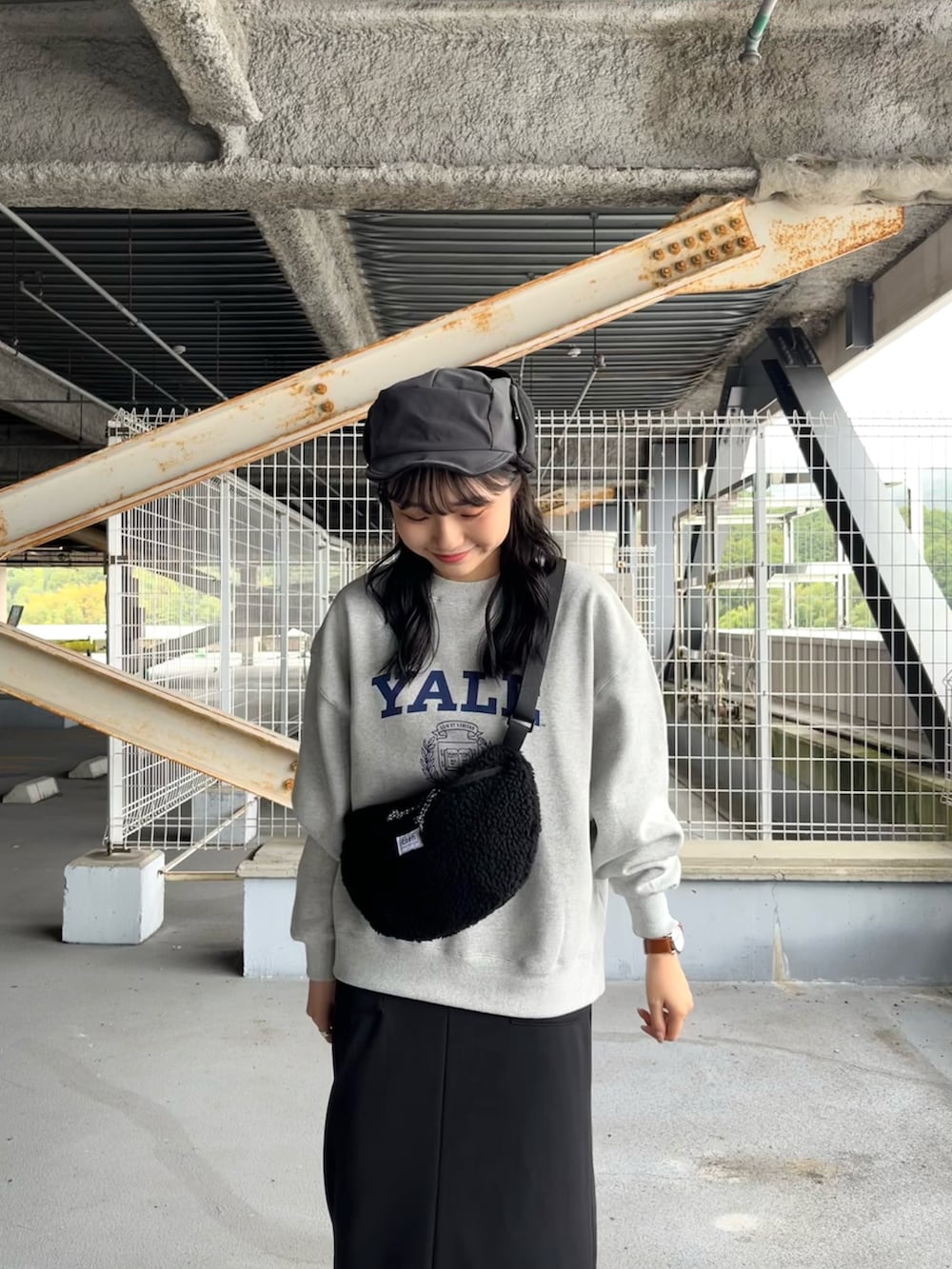 グレー系のスウェット、ブラック系のスカート、ブラック系のサンダルを着用したレディースの冬コーディネートの4枚目の写真