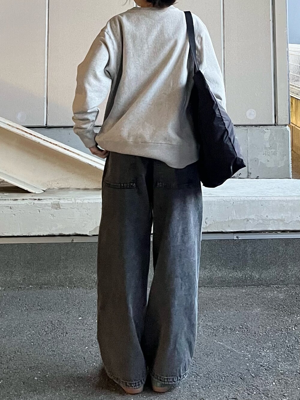 グレー系のデニムパンツ、ブラック系のトートバッグ、グリーン系のスニーカーを着用したレディースの冬コーディネートの5枚目の写真