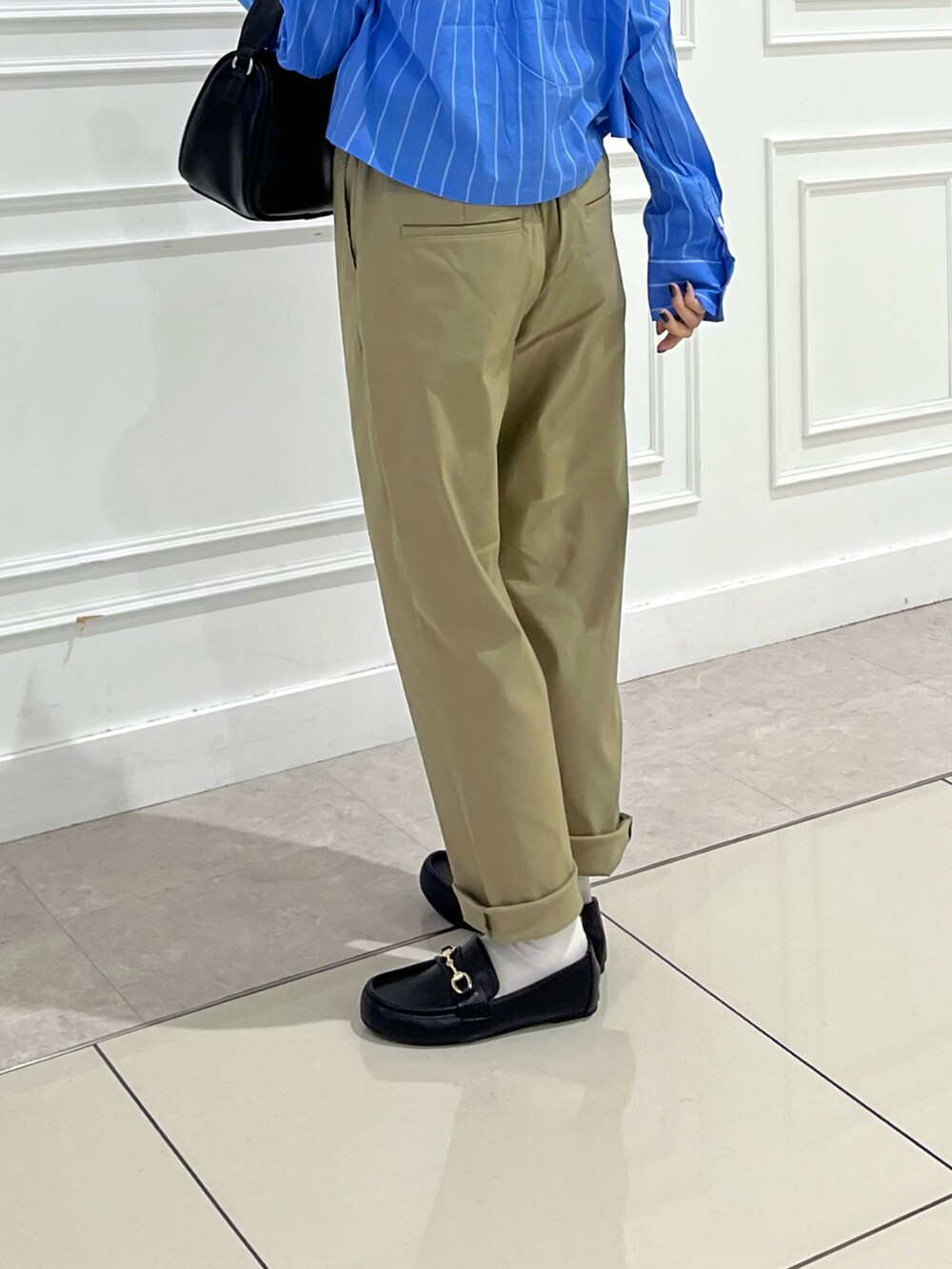 ベージュ系のその他パンツ、ブラック系のローファー、ブラック系のショルダーバッグを着用したレディースの夏コーディネートの3枚目の写真