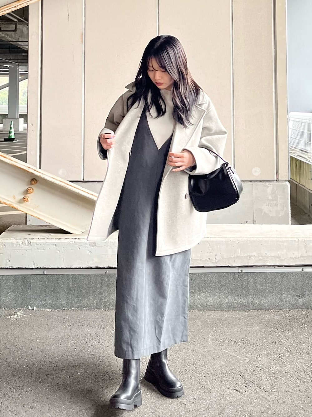 ホワイト系のニット/セーター、グレー系のジャンパースカート、グレー系のその他アウターを着用したレディースの冬コーディネートの3枚目の写真