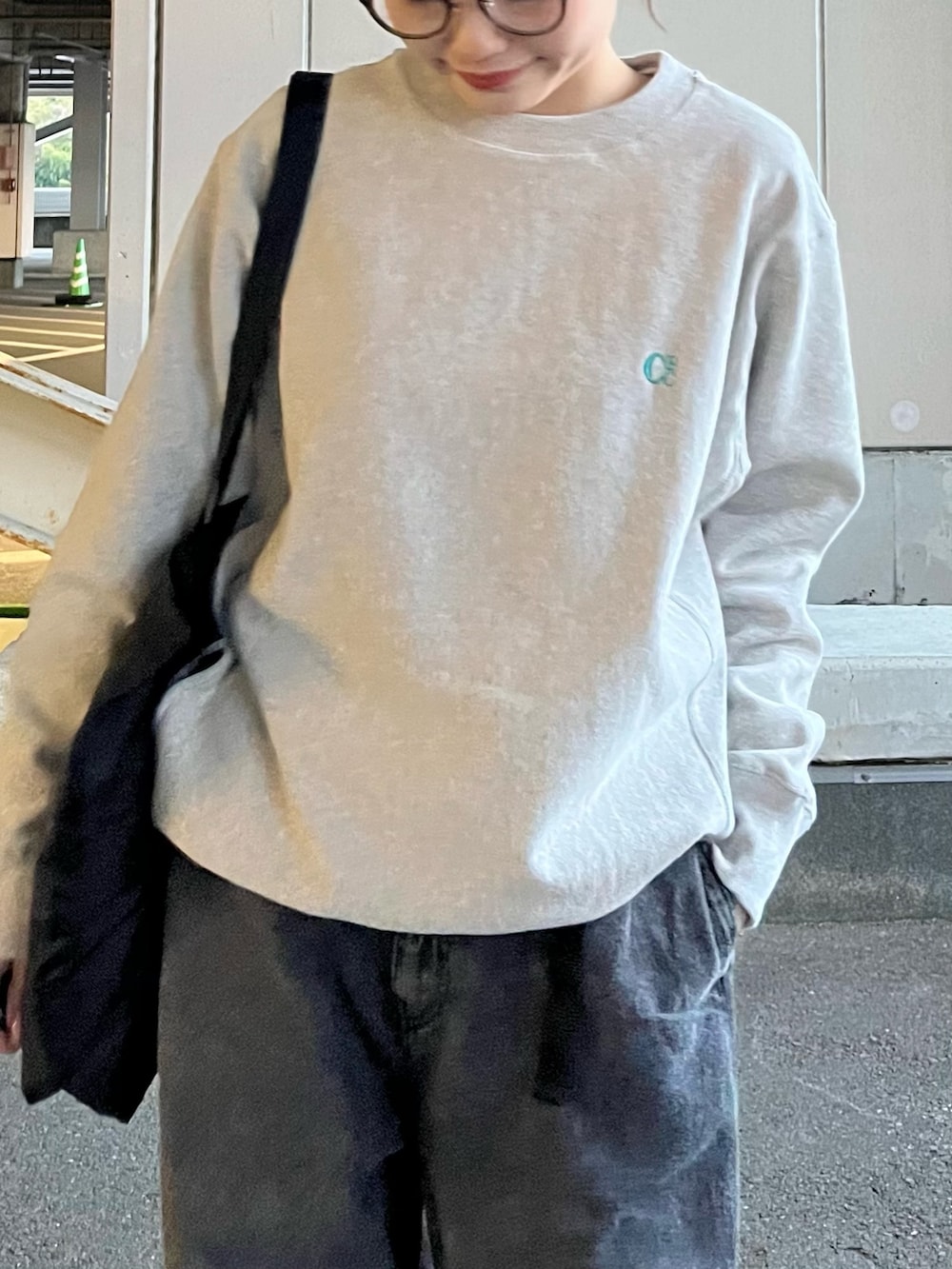 グレー系のデニムパンツ、ブラック系のトートバッグ、グリーン系のスニーカーを着用したレディースの冬コーディネートの3枚目の写真