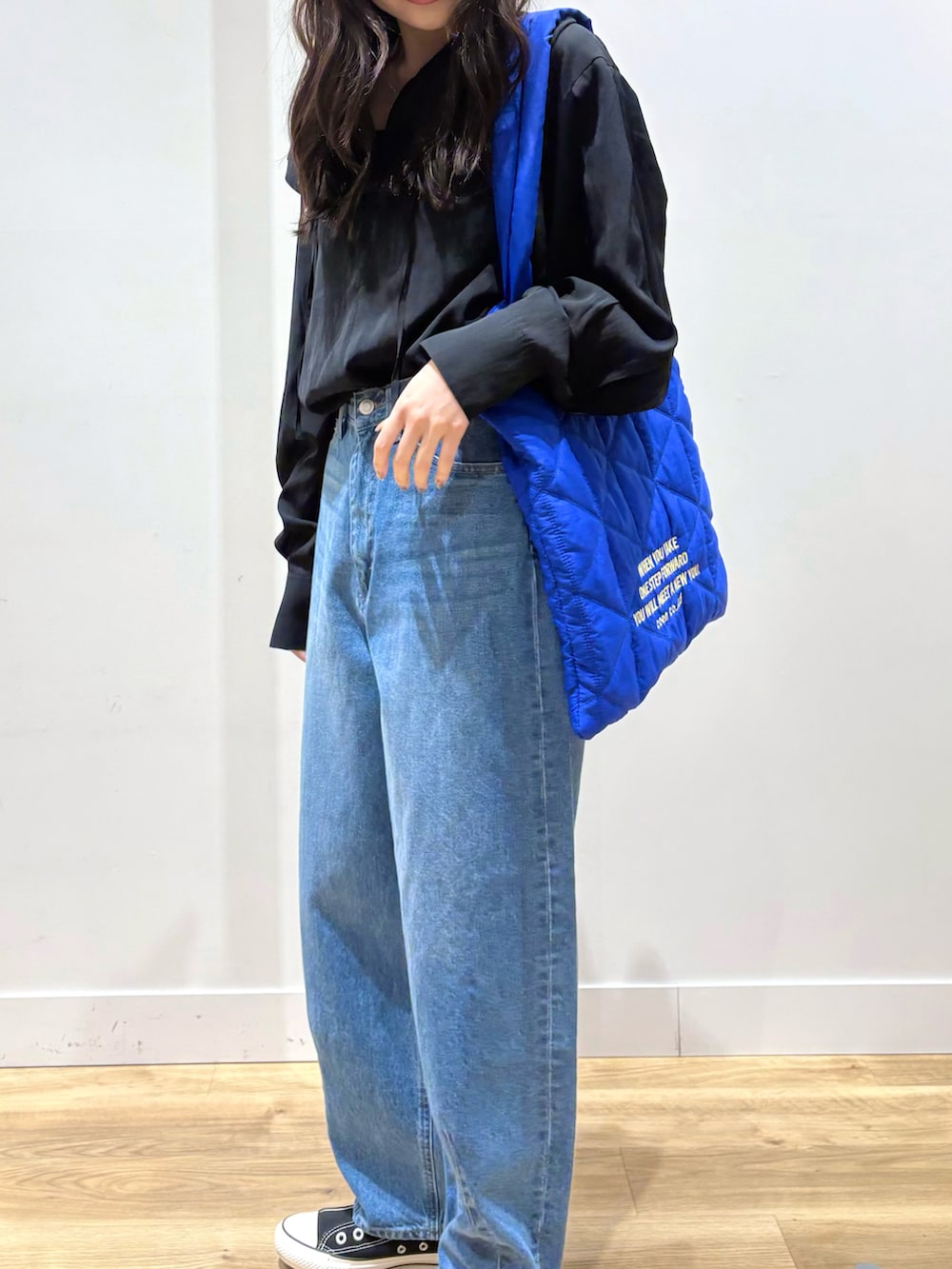 ブラック系のシャツ/ブラウス、ブルー系のデニムパンツ、ブルー系のトートバッグを着用したレディースの春コーディネートの3枚目の写真