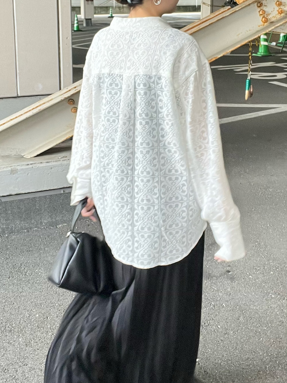 ブラック系のショルダーバッグ、ブラック系のスカート、ホワイト系のシャツ/ブラウスを着用したレディースの夏コーディネートの3枚目の写真