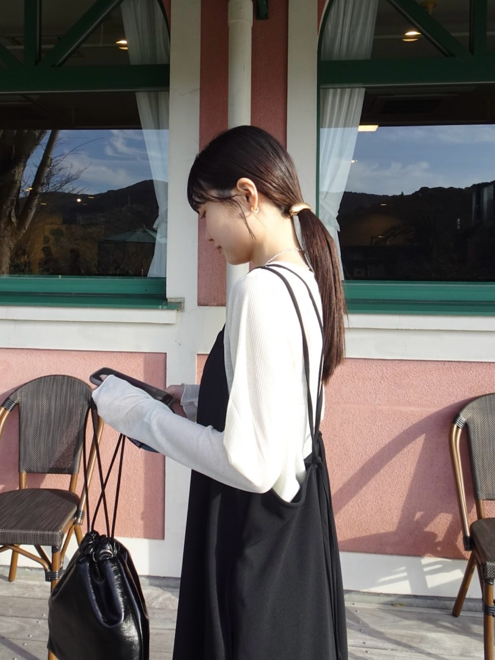 ベージュ系のTシャツ/カットソー、グレー系のサロペット/オーバーオール、ブラック系のショルダーバッグを着用したレディースの春コーディネートの2枚目の写真