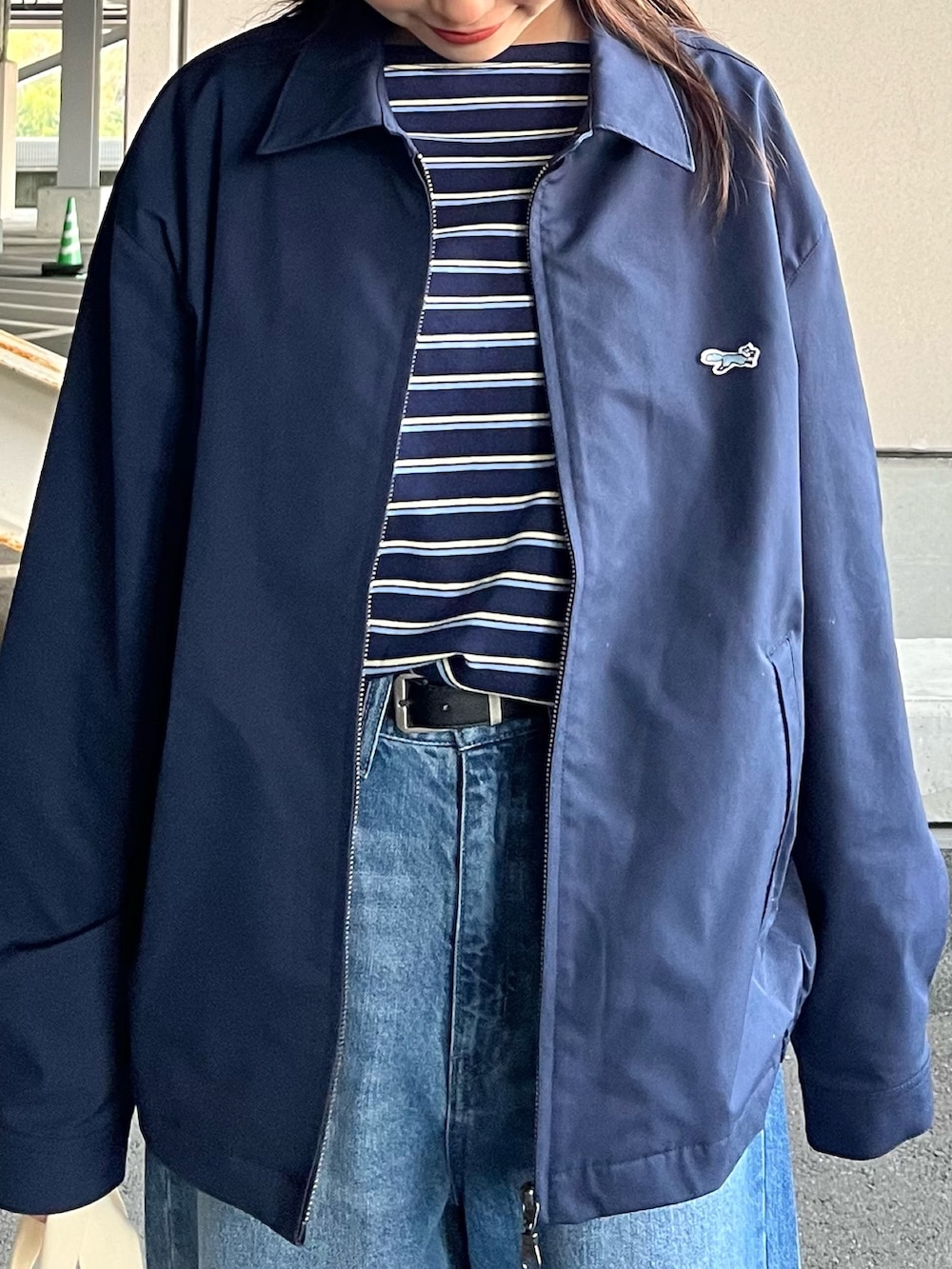 ブルー系のブルゾン、ブルー系のTシャツ/カットソー、ブルー系のデニムパンツを着用したレディースの春コーディネートの3枚目の写真