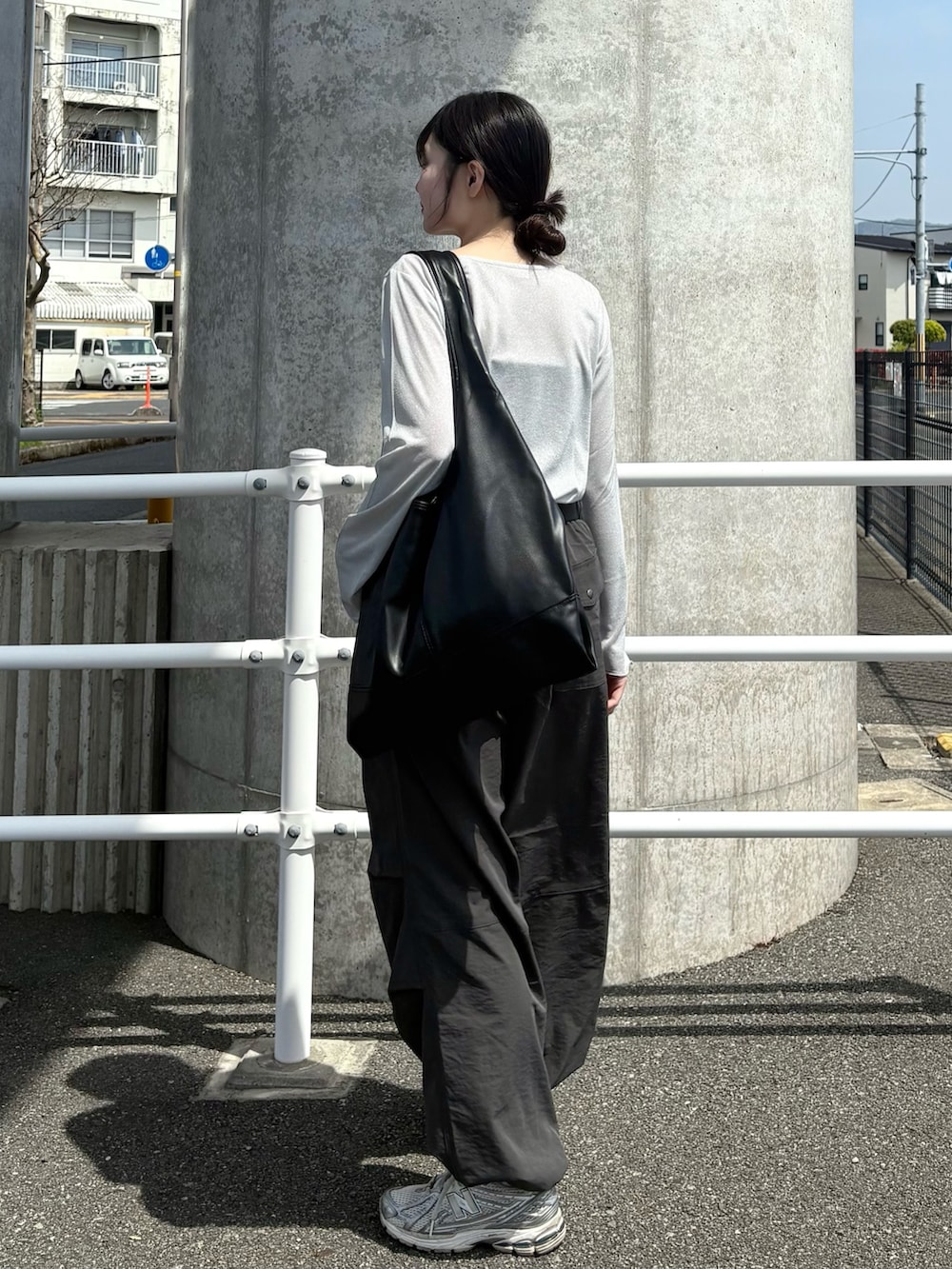 グレー系のその他パンツ、グレー系のTシャツ/カットソー、ホワイト系のスニーカーを着用したレディースの春コーディネートの2枚目の写真