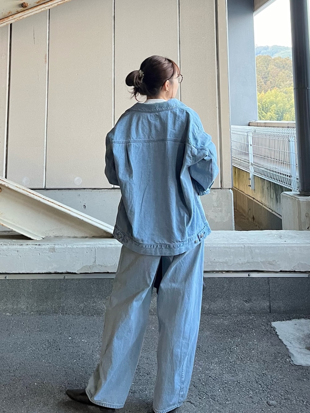 ブルー系のデニムジャケット、ブルー系のデニムパンツ、ホワイト系のTシャツ/カットソーを着用したレディースの冬コーディネートの2枚目の写真