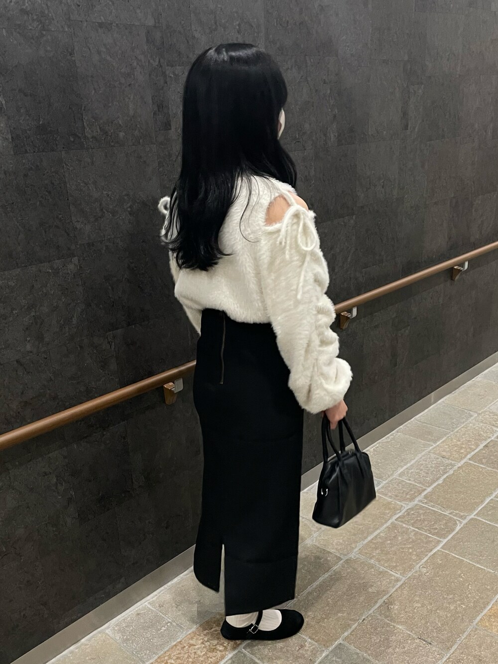 ホワイト系のニット/セーター、ブラック系のスカート、ブラック系のバレエシューズを着用したレディースの冬コーディネートの3枚目の写真