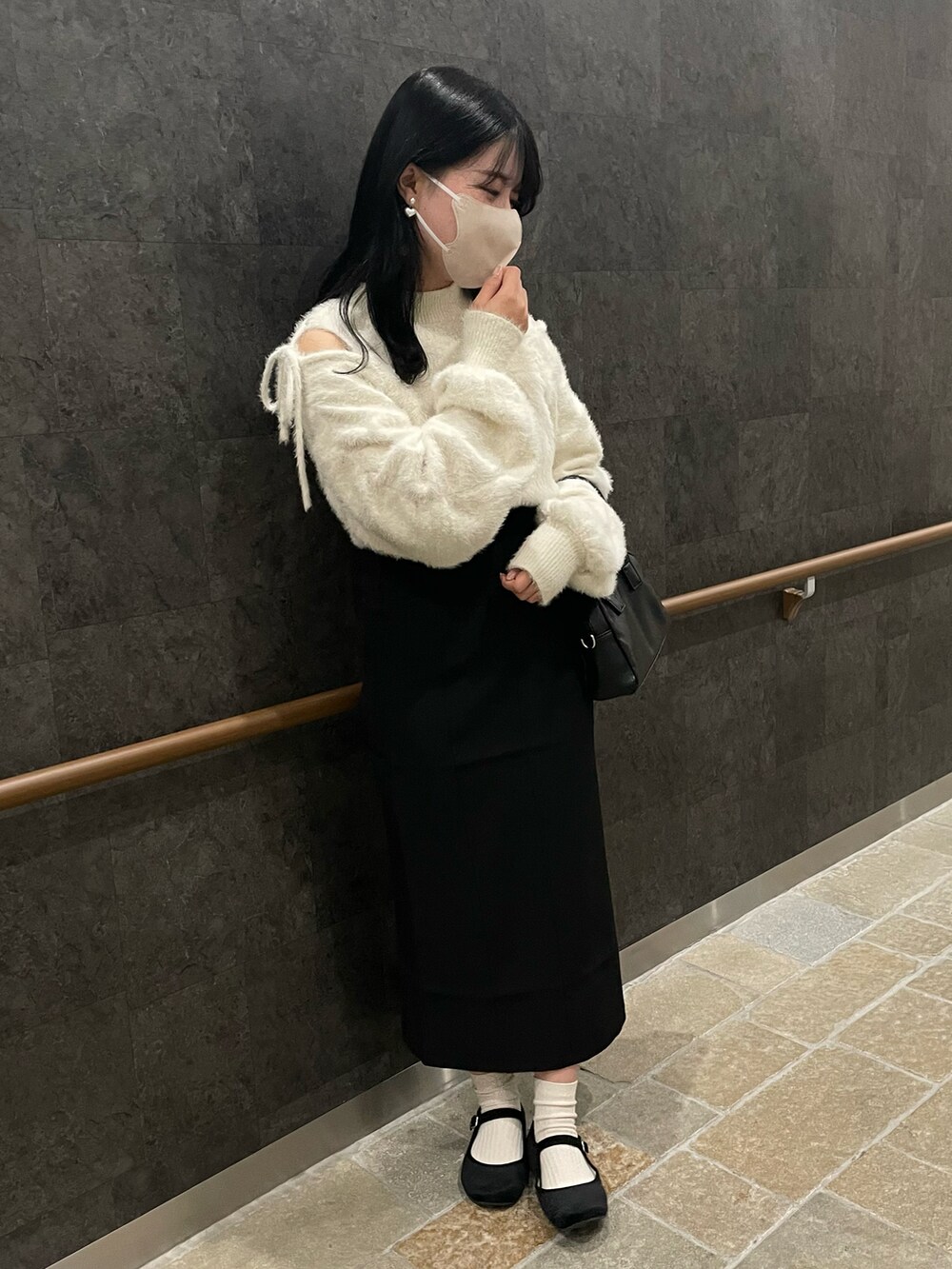 ホワイト系のニット/セーター、ブラック系のスカート、ブラック系のバレエシューズを着用したレディースの冬コーディネートの2枚目の写真
