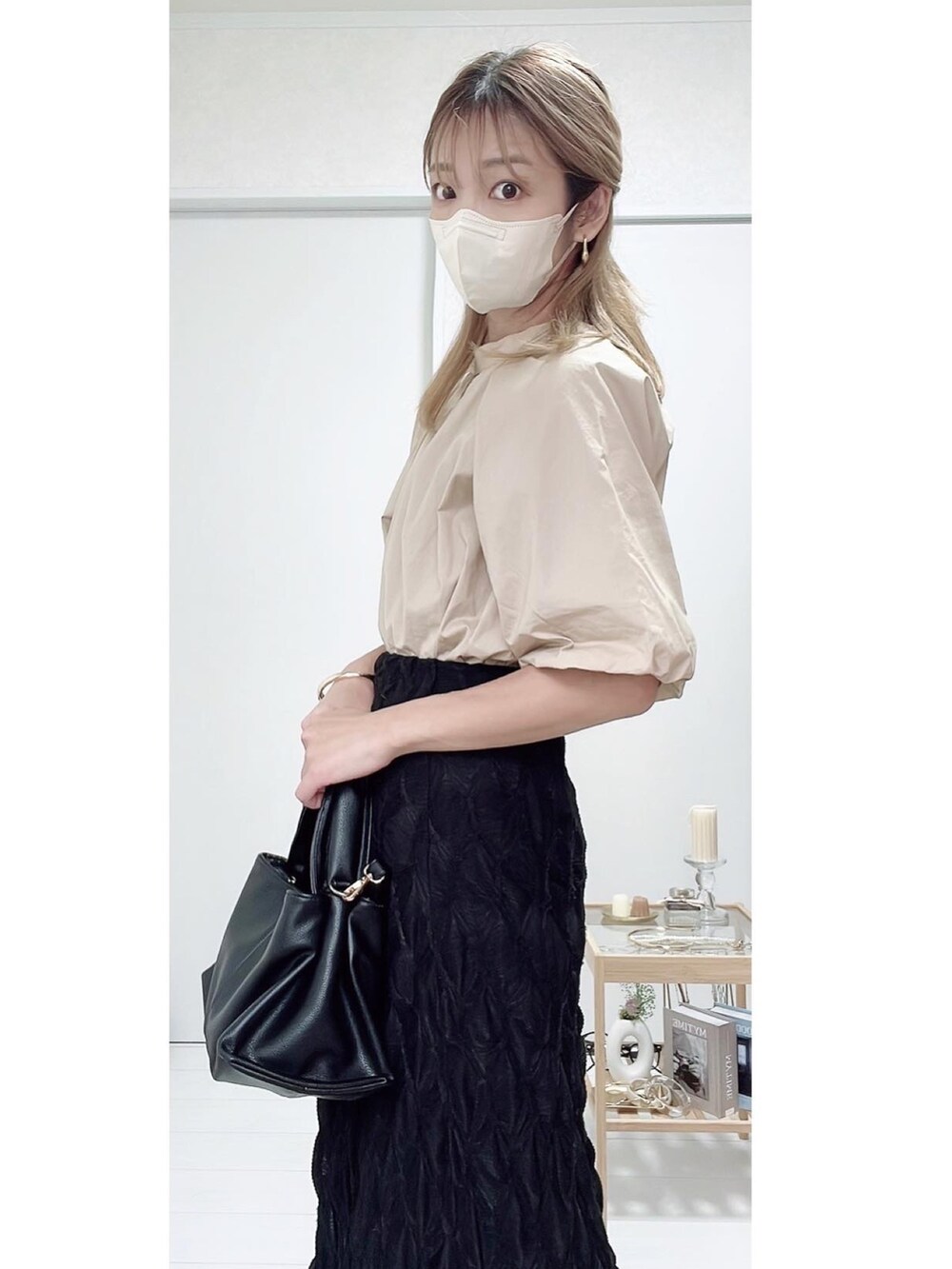 ブラック系のパンプス、ブラック系のスカート、ベージュ系のシャツ/ブラウスを着用したレディースの秋コーディネートの3枚目の写真