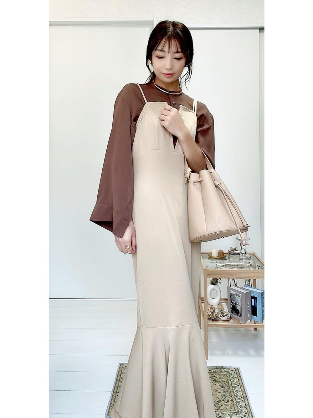 ベージュ系のハンドバッグ、ベージュ系のワンピース、ブラウン系のシャツ/ブラウスを着用したレディースの秋コーディネートの2枚目の写真