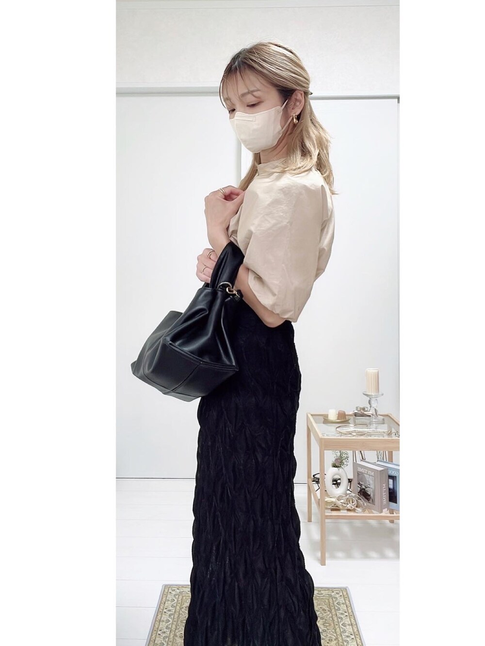 ブラック系のパンプス、ブラック系のスカート、ベージュ系のシャツ/ブラウスを着用したレディースの秋コーディネートの2枚目の写真