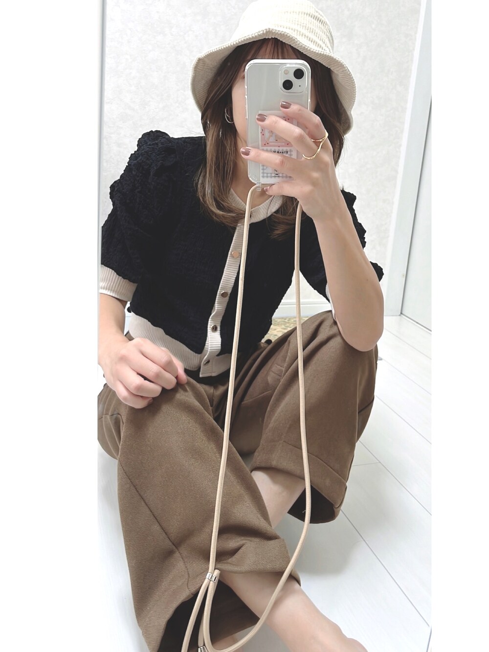 ブラック系のカーディガン/ボレロ、ブラウン系のハンドバッグ、ブラウン系のスラックスを着用したレディースの秋コーディネートの3枚目の写真