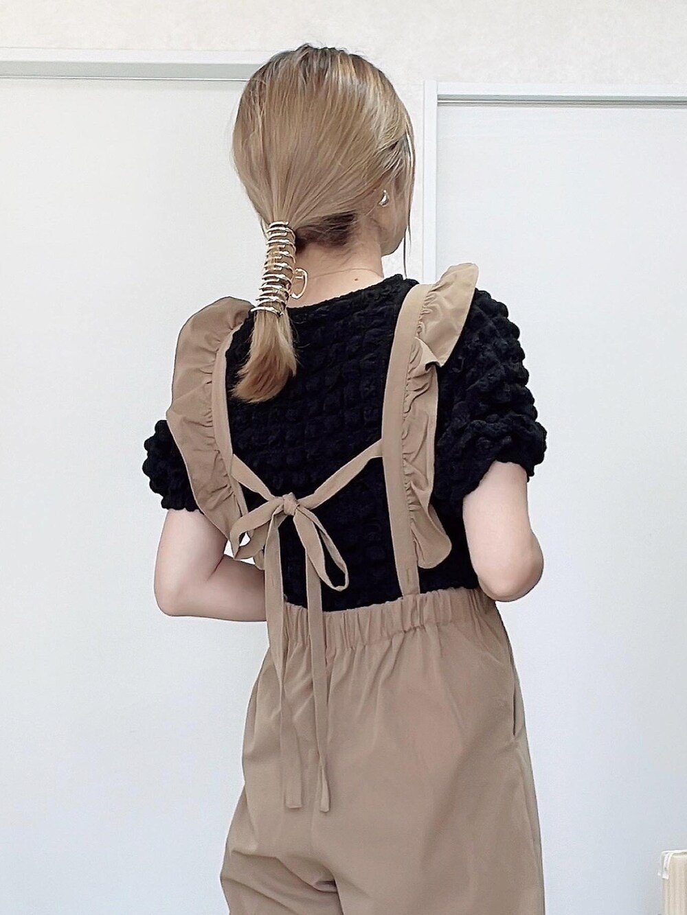 ブラック系のスニーカー、その他のトートバッグ、ベージュ系のサロペット/オーバーオールを着用したレディースの秋コーディネートの5枚目の写真