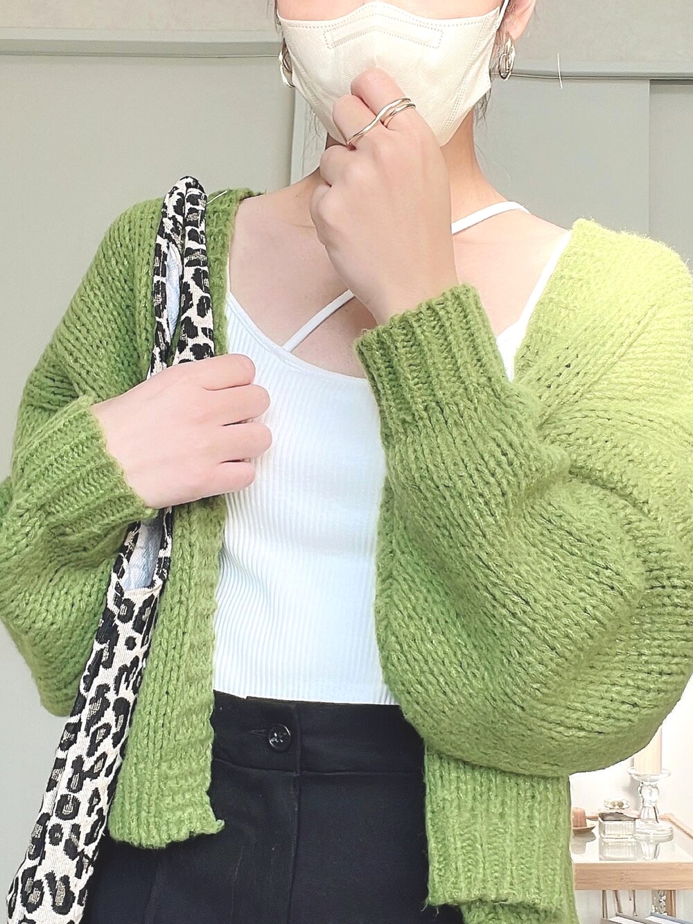 ホワイト系のキャミソール、グリーン系のカーディガン/ボレロ、ブラック系のその他パンツを着用したレディースの秋コーディネートの3枚目の写真