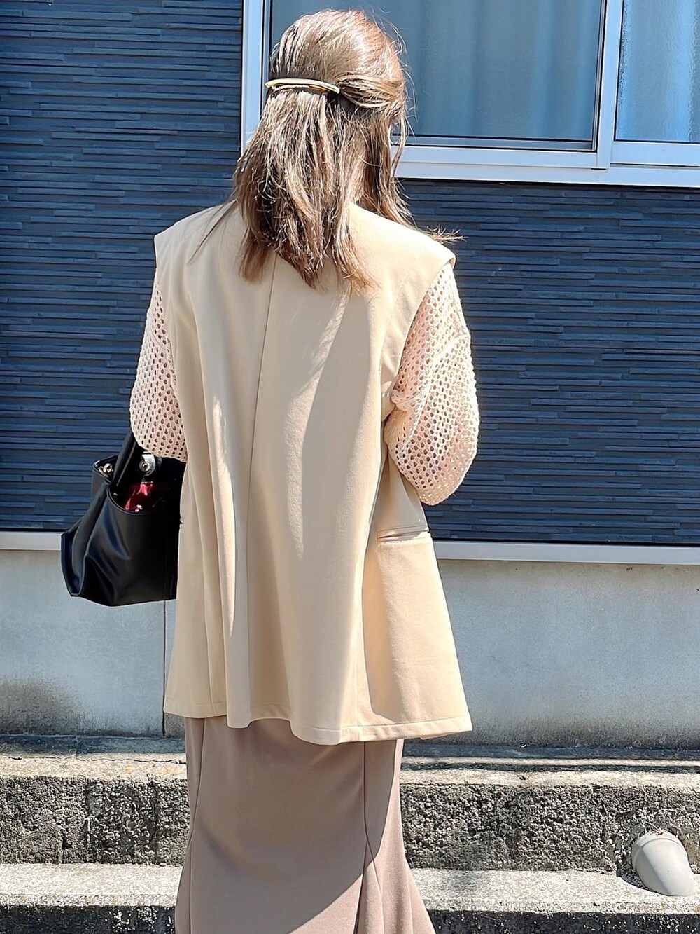 ベージュ系のニット/セーター、ベージュ系のその他アウター、ベージュ系のスカートを着用したレディースの秋コーディネートの2枚目の写真