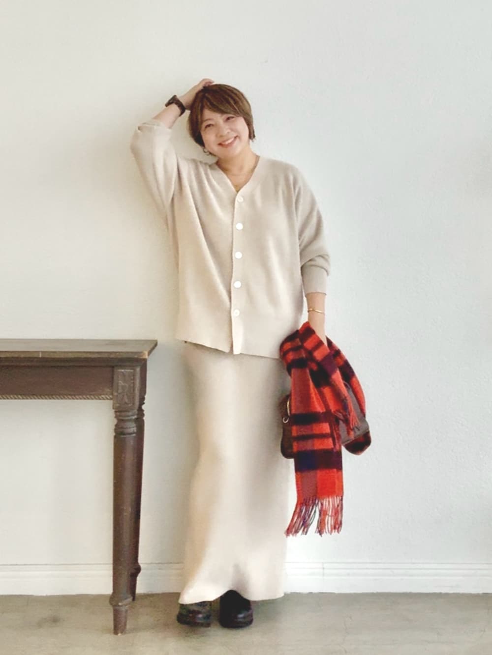 ホワイト系のニット/セーター、ホワイト系のスカートを着用したレディースの秋コーディネートの2枚目の写真