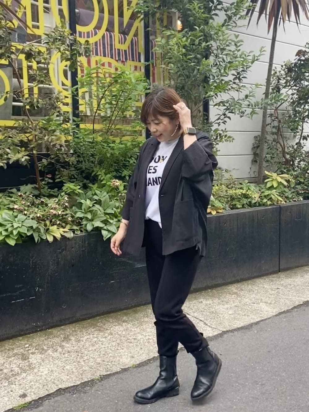 ブラック系のテーラードジャケット、ホワイト系のTシャツ/カットソー、ブラック系のスウェットパンツを着用したレディースの春コーディネートの2枚目の写真