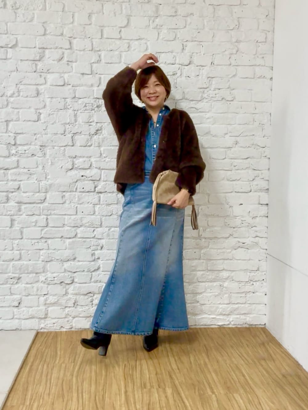 ブラウン系のカーディガン/ボレロ、ブルー系のシャツ/ブラウス、ブルー系のデニムスカートを着用したレディースの秋コーディネートの4枚目の写真