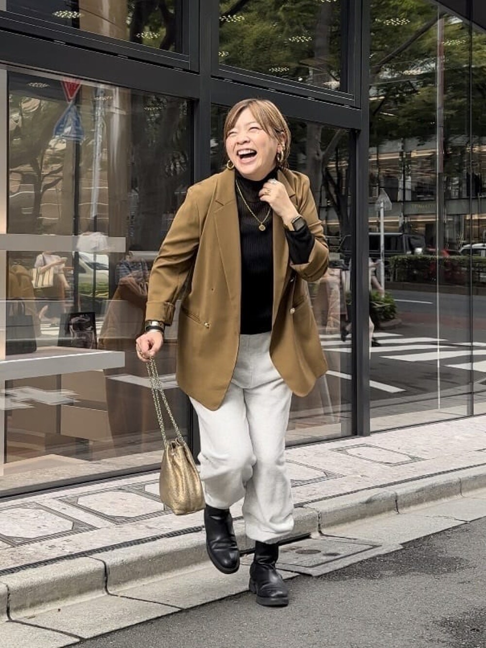 ブラウン系のテーラードジャケット、ブラック系のニット/セーター、グレー系のスウェットパンツを着用したレディースの秋コーディネートの3枚目の写真