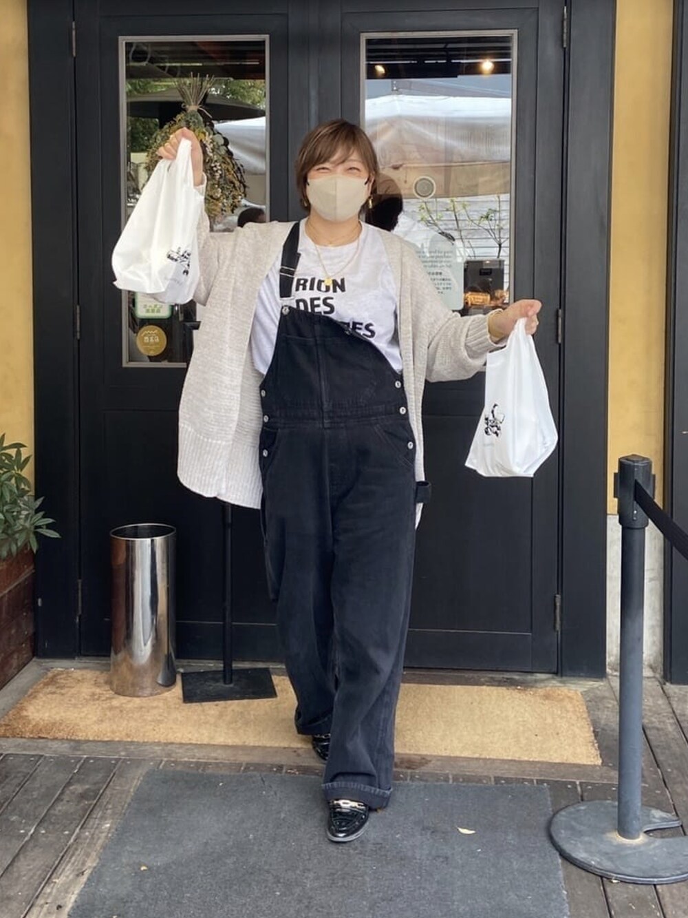 グレー系のカーディガン/ボレロ、ブラック系のサロペット/オーバーオールを着用したレディースの春コーディネートの2枚目の写真