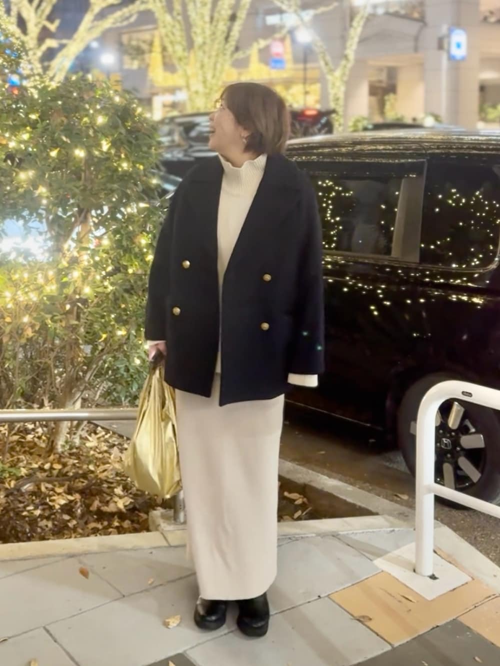 ホワイト系のニット/セーター、ホワイト系のスカート、ブラック系のブーツを着用したレディースの冬コーディネートの3枚目の写真