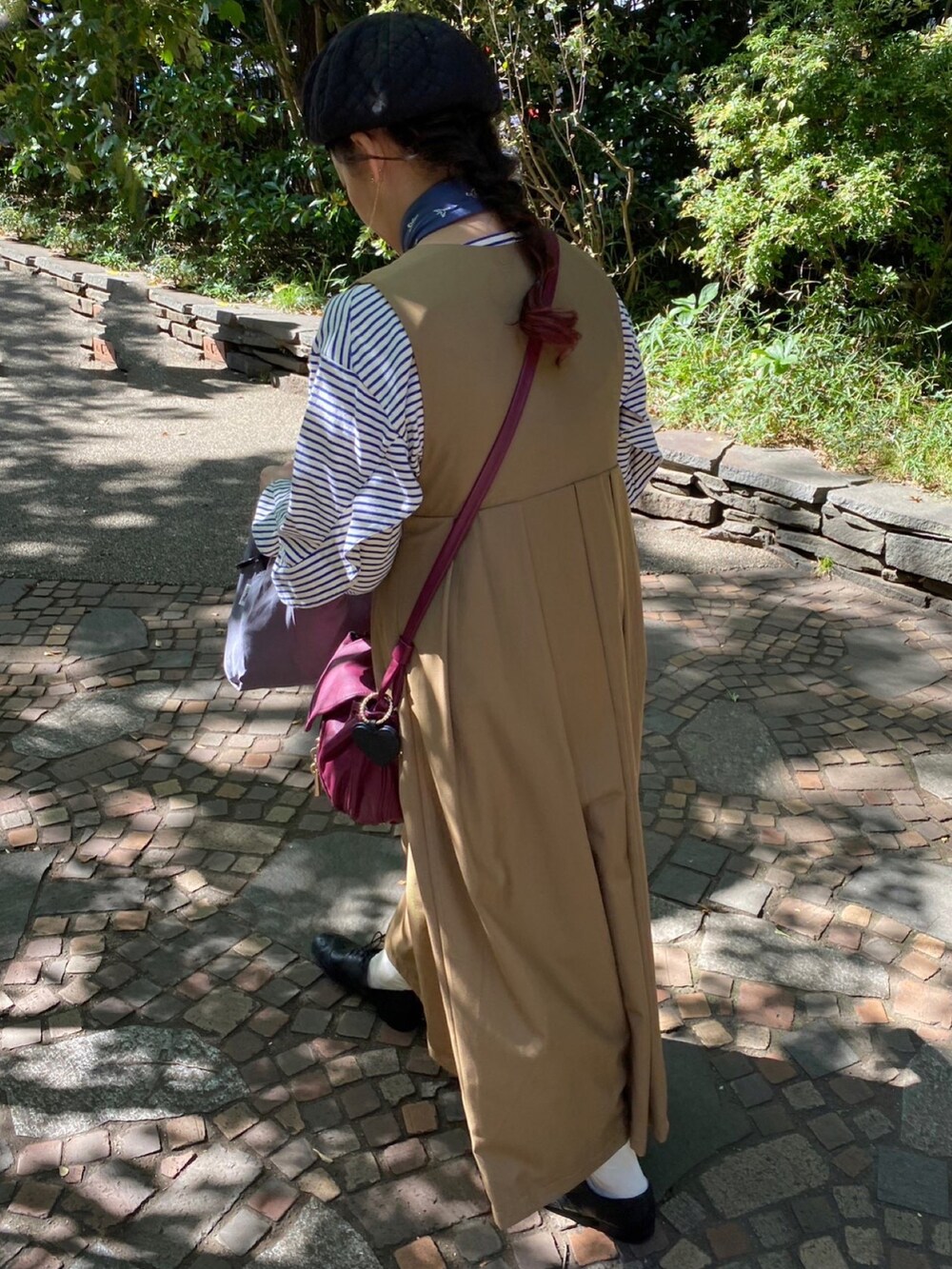 ベージュ系のワンピース、ブルー系のTシャツ/カットソー、パープル系のショルダーバッグを着用したレディースの秋コーディネートの2枚目の写真