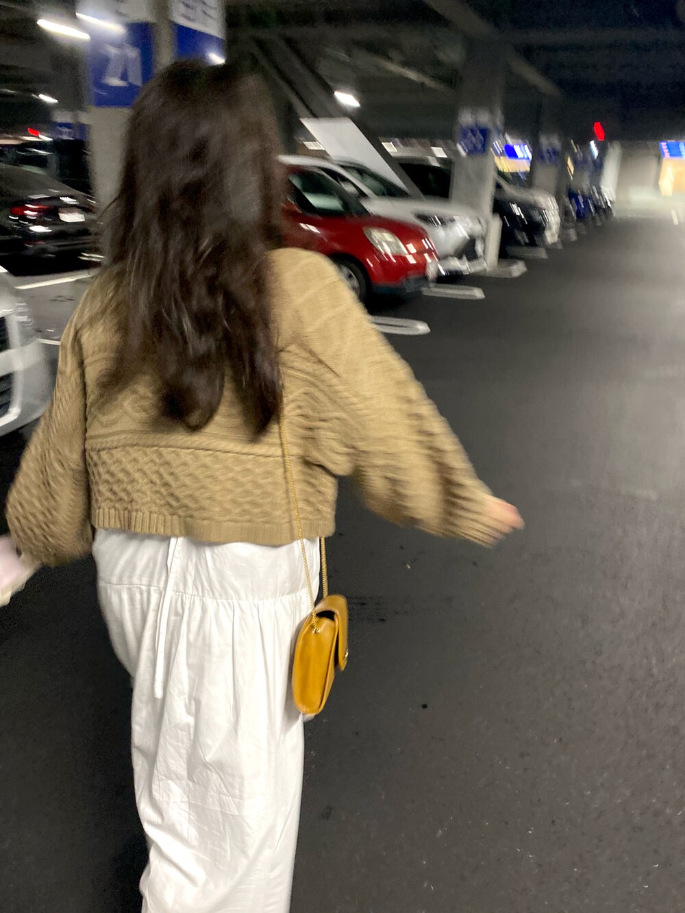 ブラウン系のニット/セーター、ゴールド系のショルダーバッグ、ホワイト系のワンピースを着用したレディースの秋コーディネートの2枚目の写真