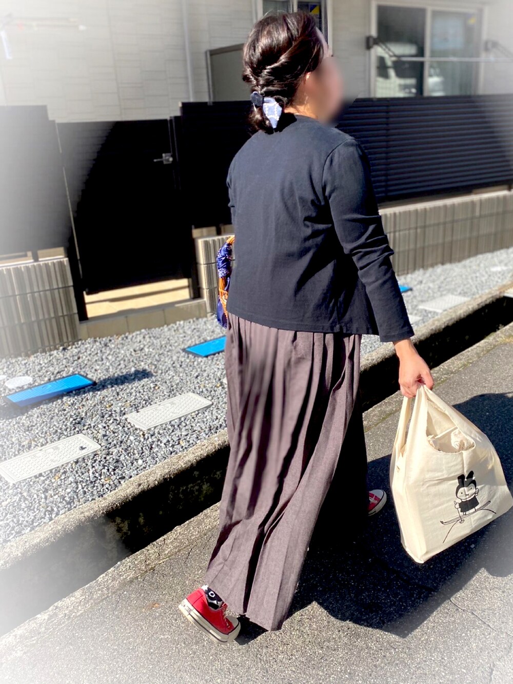 ホワイト系のTシャツ/カットソー、ブラック系のカーディガン/ボレロ、グレー系のワンピースを着用したレディースの秋コーディネートの2枚目の写真