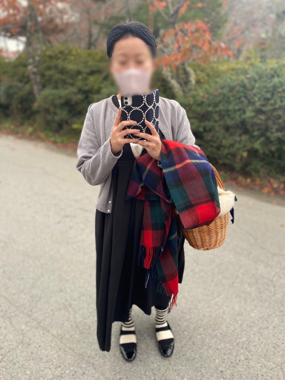 グレー系のカーディガン/ボレロ、ブラック系のワンピース、ブラウン系のかごバッグを着用したレディースの秋コーディネートの2枚目の写真