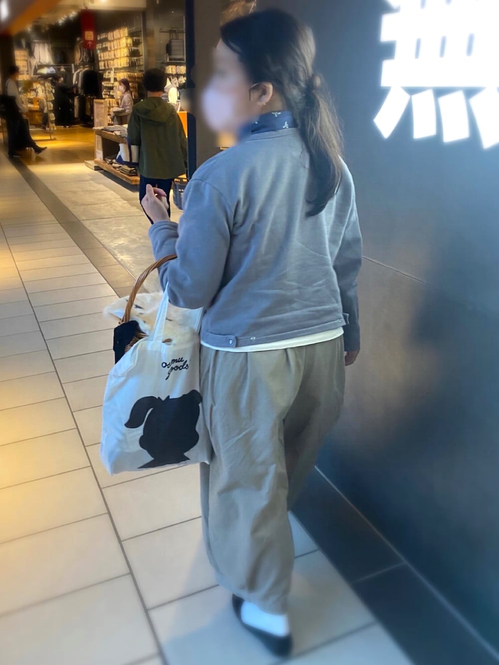 グレー系のカーディガン/ボレロ、ブラウン系のかごバッグ、ベージュ系のパンツを着用したレディースの秋コーディネートの2枚目の写真