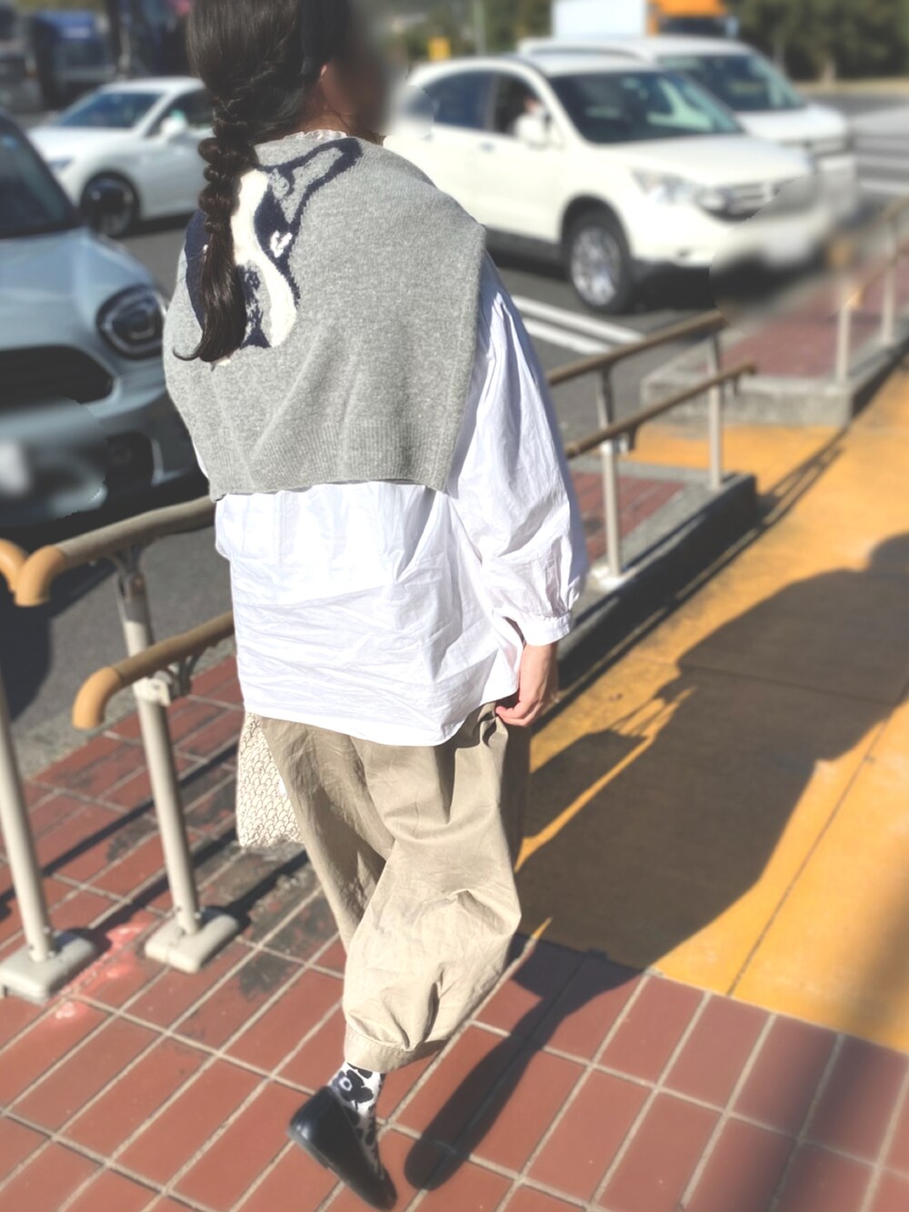ベージュ系のパンツ、ホワイト系のシャツ/ブラウス、グレー系のニット/セーターを着用したレディースの秋コーディネートの2枚目の写真
