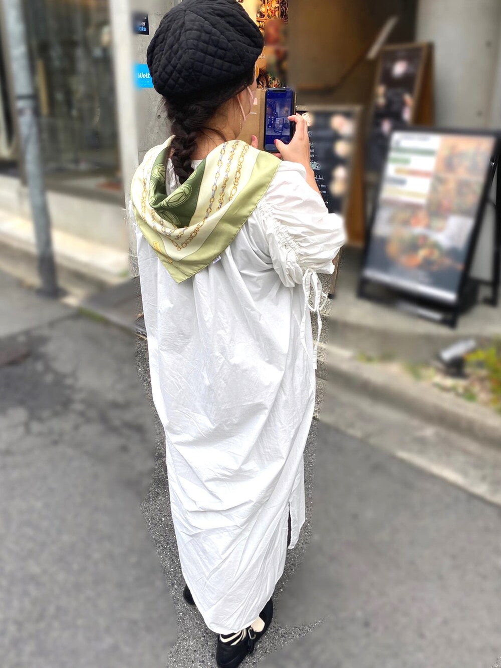 ホワイト系のワンピース、ブラック系のハンドバッグ、ブラック系のシューズを着用したレディースの秋コーディネートの2枚目の写真