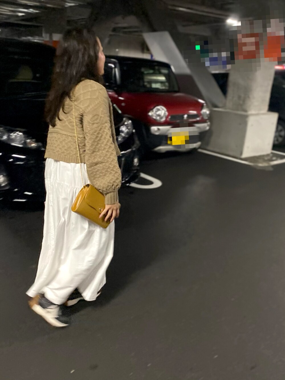 ブラウン系のニット/セーター、ゴールド系のショルダーバッグ、ホワイト系のワンピースを着用したレディースの秋コーディネートの3枚目の写真