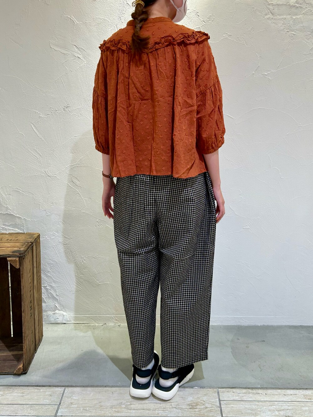 オレンジ系のシャツ/ブラウス、ブラック系のパンツ、ブラック系のサンダルを着用したレディースの夏コーディネートの3枚目の写真