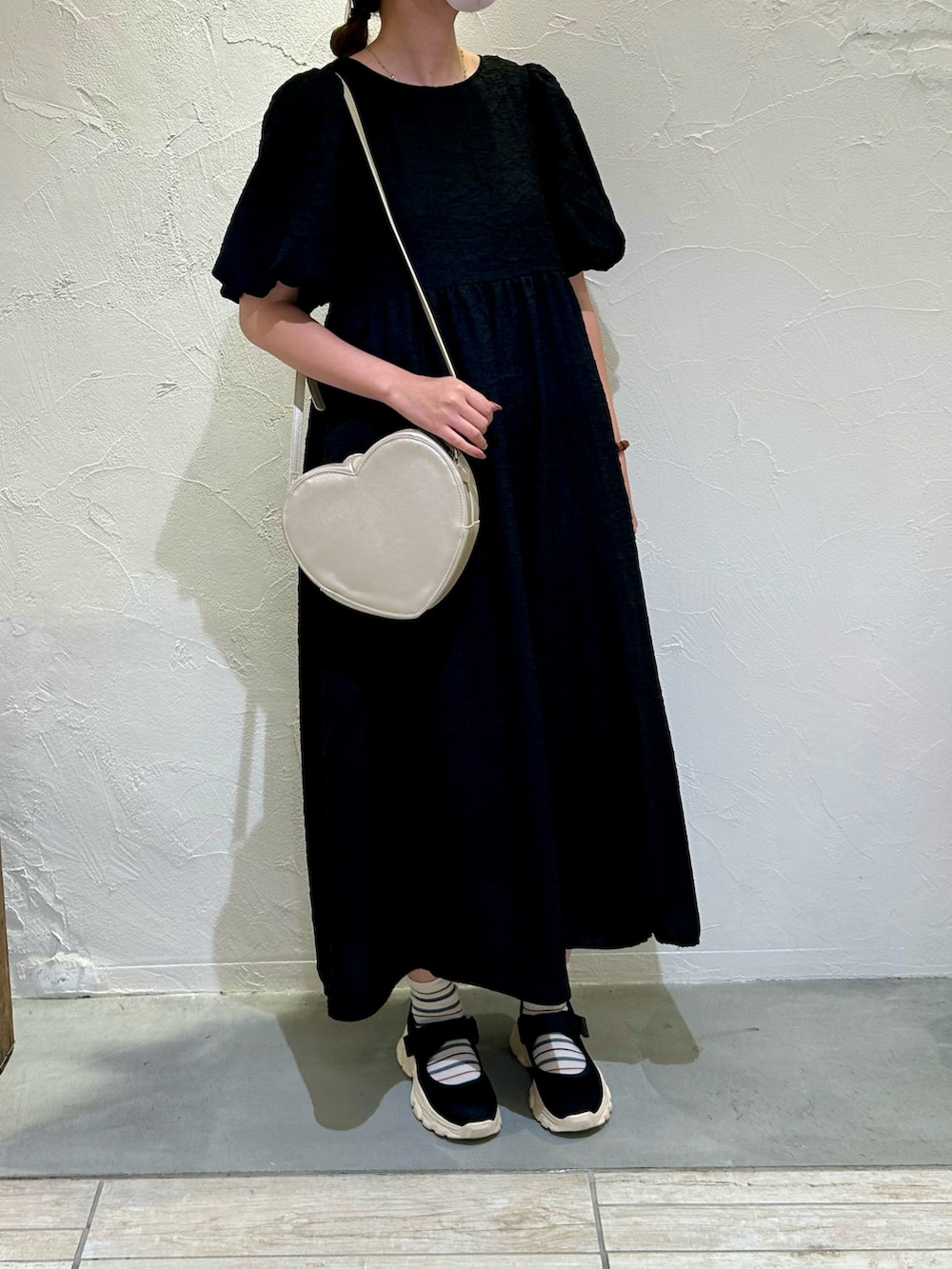 ブラック系のワンピース、シルバー系のハンドバッグを着用したレディースの秋コーディネートの2枚目の写真