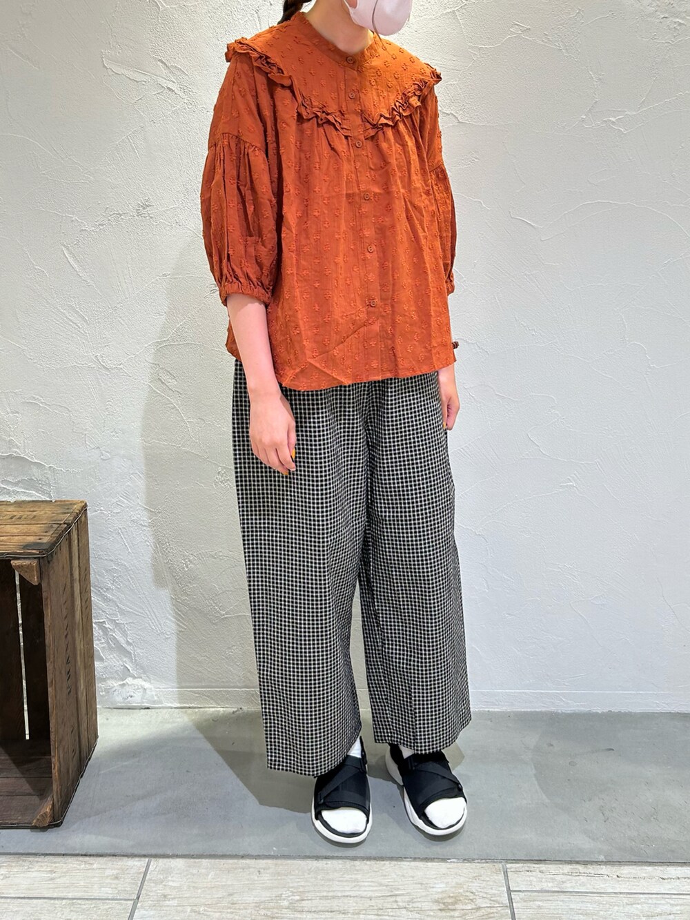 オレンジ系のシャツ/ブラウス、ブラック系のパンツ、ブラック系のサンダルを着用したレディースの夏コーディネートの4枚目の写真