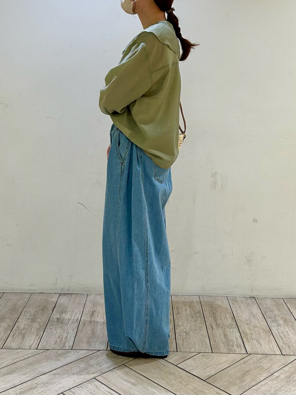 グリーン系のシャツ/ブラウス、ブルー系のデニムパンツ、ベージュ系のショルダーバッグを着用したレディースの夏コーディネートの2枚目の写真