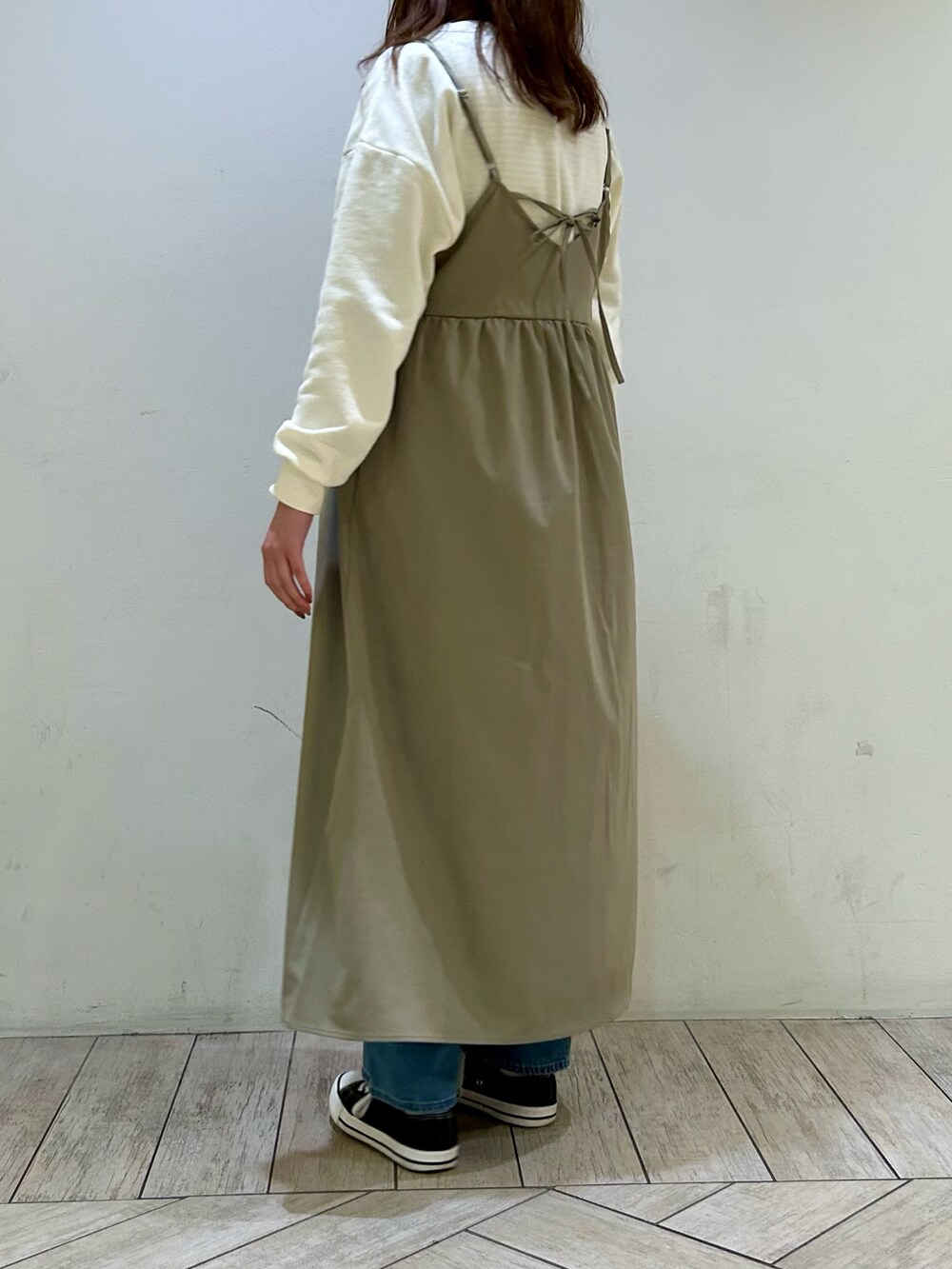 ホワイト系のTシャツ/カットソー、グリーン系のワンピース、ブルー系のデニムパンツを着用したレディースの冬コーディネートの2枚目の写真