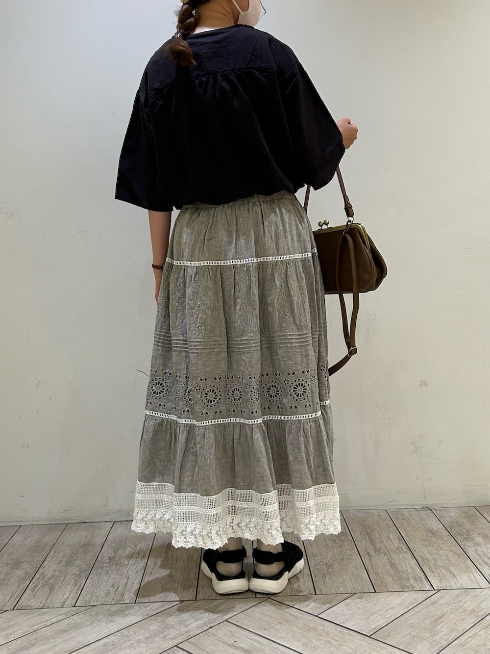 ブラック系のシャツ/ブラウス、ブラウン系のバッグ、グレー系のスカートを着用したレディースの夏コーディネートの2枚目の写真