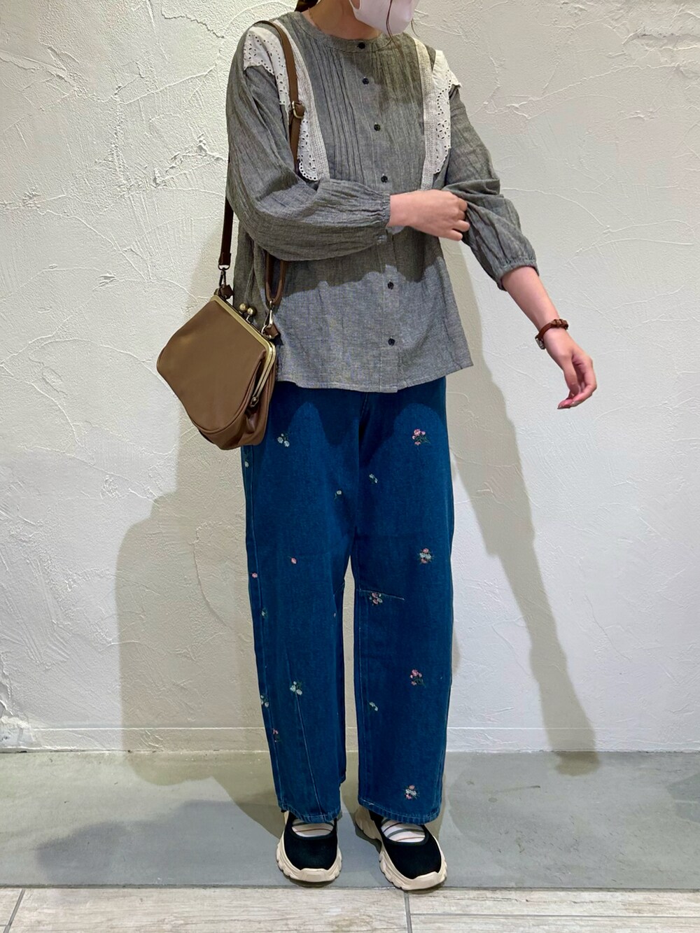 ブラック系のシャツ/ブラウス、ブルー系のデニムパンツ、ブラウン系のバッグを着用したレディースの秋コーディネートの2枚目の写真