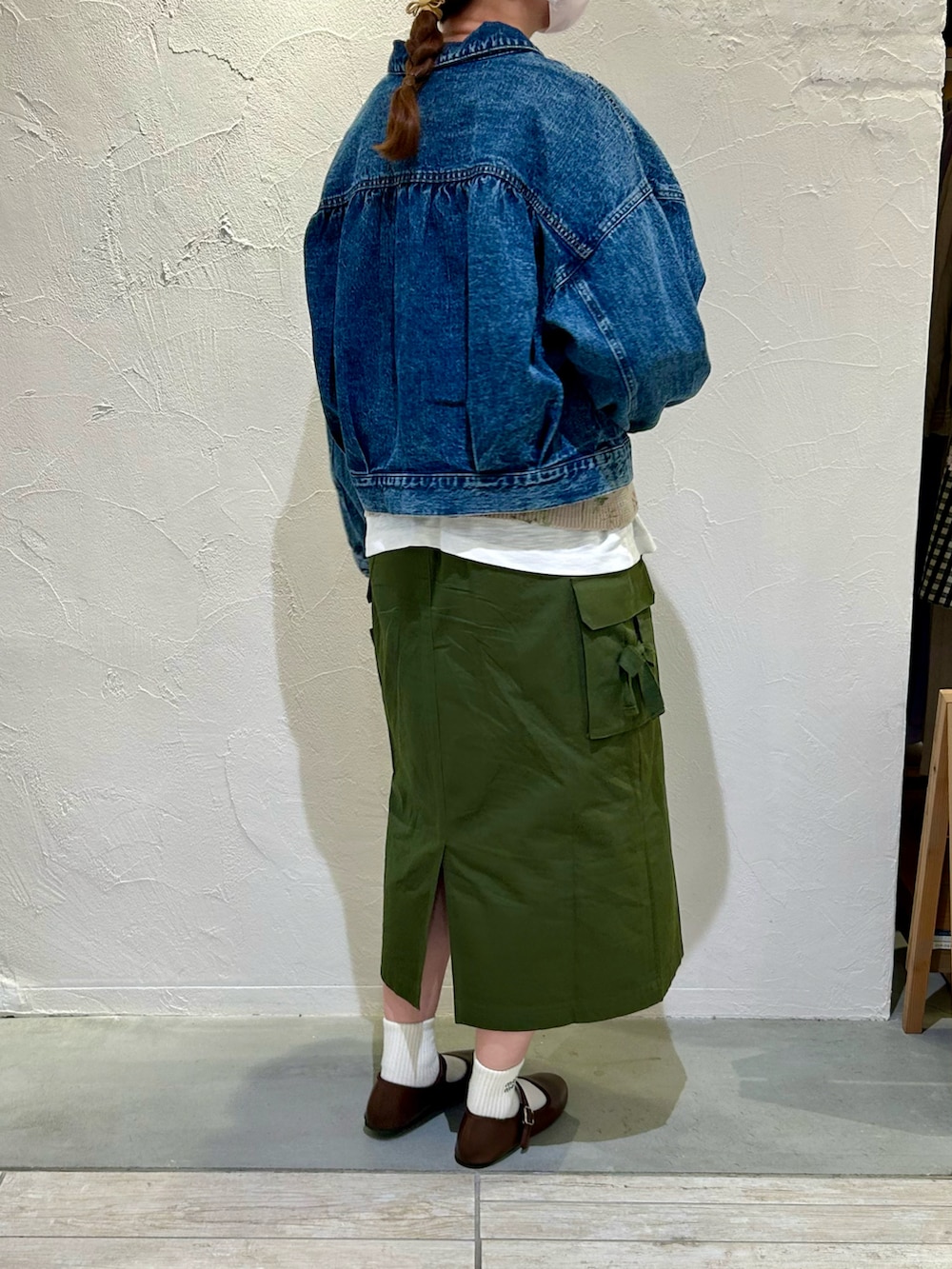 ブルー系のデニムジャケット、ベージュ系のベスト、ホワイト系のTシャツ/カットソーを着用したレディースの春コーディネートの2枚目の写真