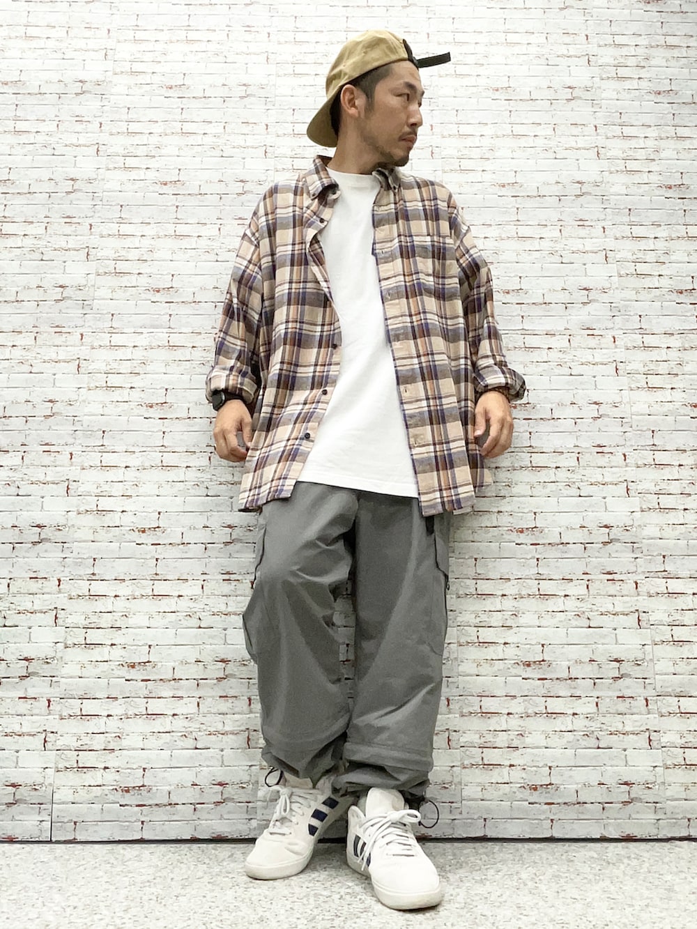 ブラウン系のシャツ/ブラウス、ホワイト系のTシャツ/カットソー、グリーン系のカーゴパンツを着用したメンズの秋コーディネートの3枚目の写真