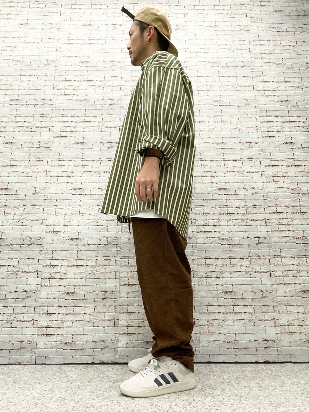 グリーン系のシャツ/ブラウス、ホワイト系のTシャツ/カットソー、ベージュ系のチノパンツを着用したメンズの秋コーディネートの2枚目の写真