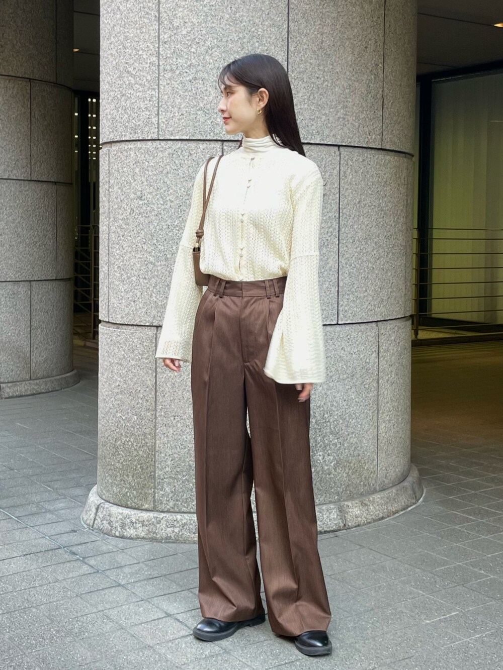 ベージュ系のシャツ/ブラウス、ブラウン系のスラックス、ベージュ系のダウンジャケット/コートを着用したレディースの冬コーディネートの2枚目の写真