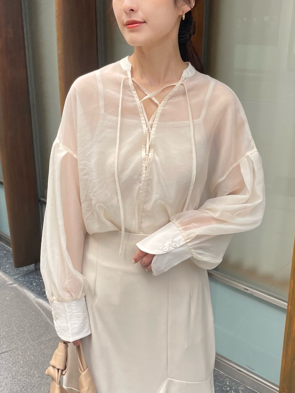 ホワイト系のシャツ/ブラウスを着用したレディースの夏コーディネートの2枚目の写真