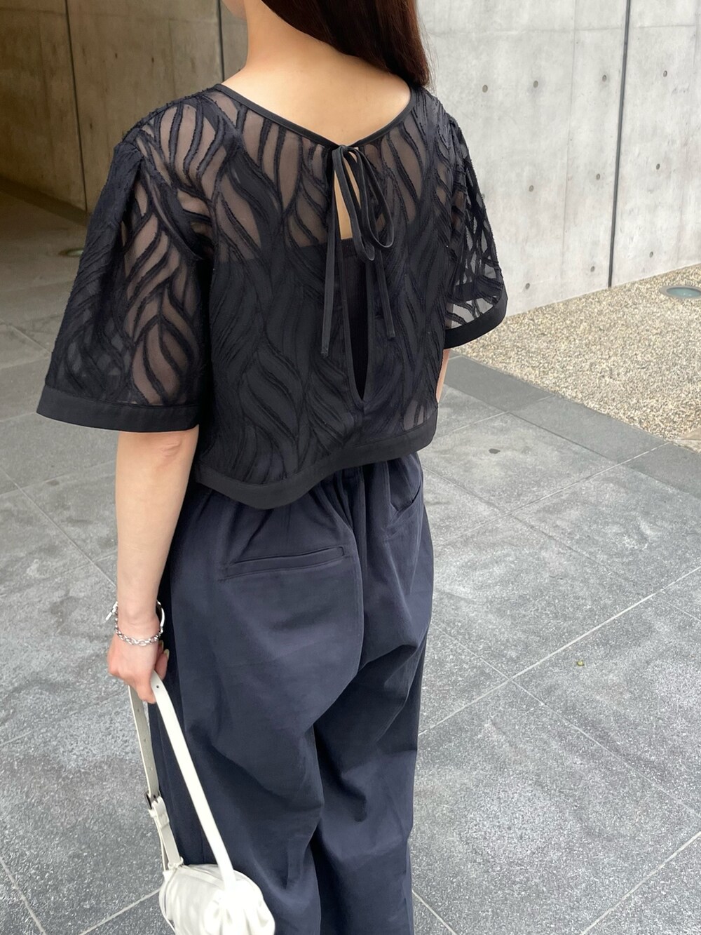 ブラック系のシャツ/ブラウス、ブルー系のスラックスを着用したレディースの春コーディネートの4枚目の写真