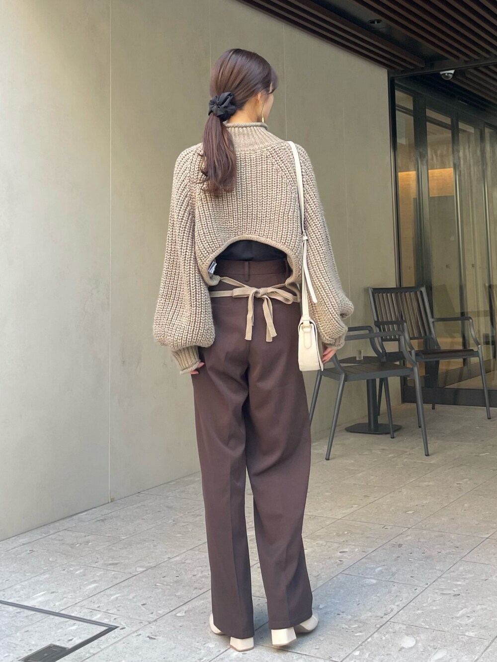 ベージュ系のニット/セーター、ゴールド系のピアス（両耳用）を着用したレディースの秋コーディネートの2枚目の写真