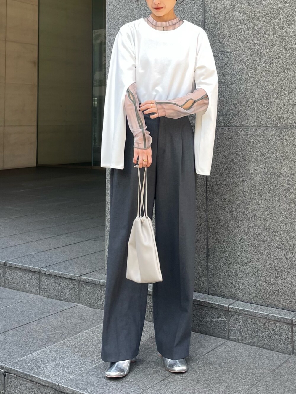 ベージュ系のTシャツ/カットソー、ホワイト系のTシャツ/カットソー、グレー系のパンツを着用したレディースの冬コーディネートの2枚目の写真