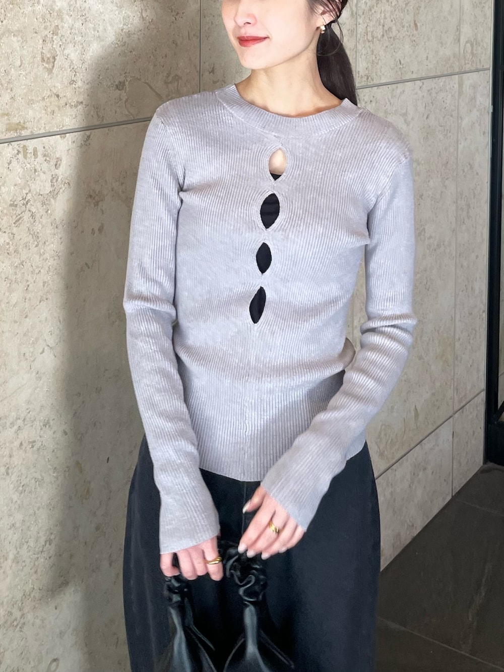 グレー系のニット/セーター、ブラック系のデニムパンツ、ホワイト系のスニーカーを着用したレディースの冬コーディネートの3枚目の写真